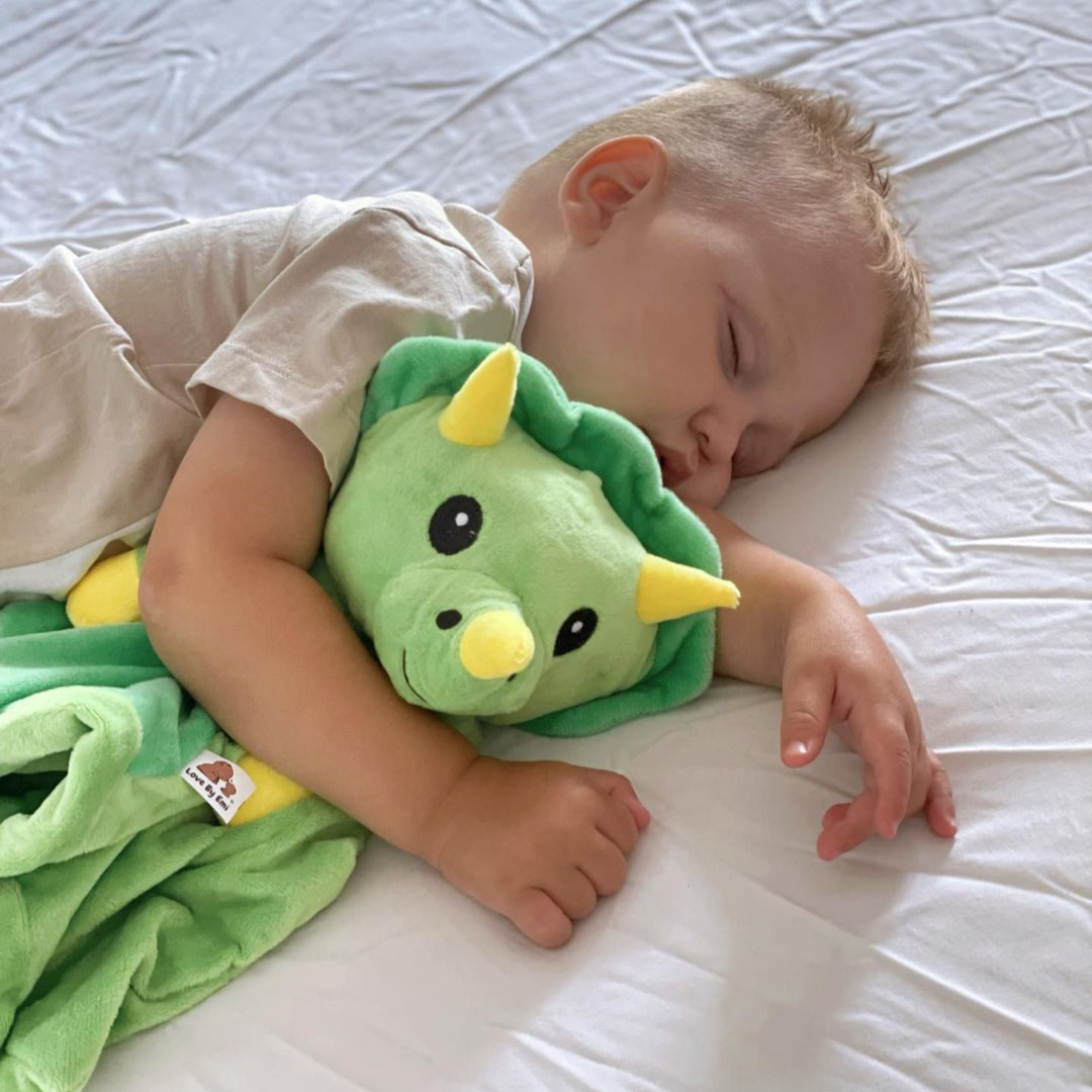 image of toddler boy sleeping soundly with his favorite white noise and lullaby toy from Love By Emi - Dash the Dinosaur 